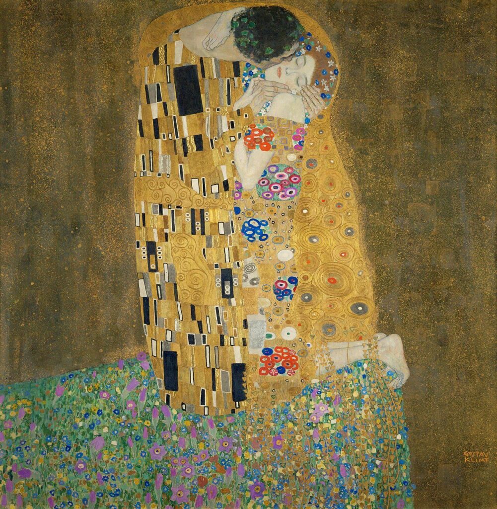 金の衣に包まれた男女。男が女の頬に口づけている。女は目を閉じ、首を傾けている。二人は花の草地の端に膝をついている。